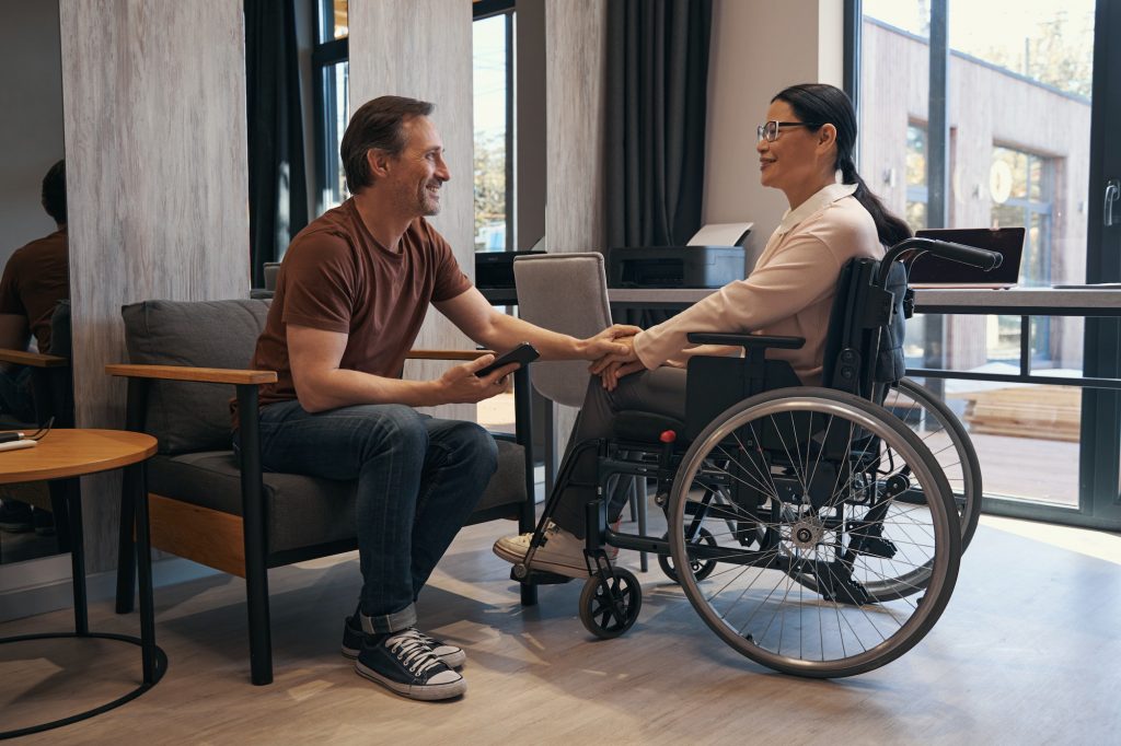 Cheerful man enjoying communication with woman with disability