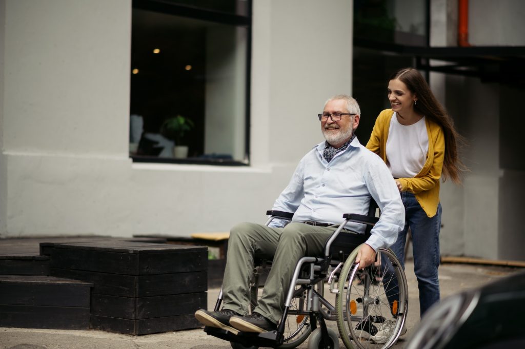 Daughter and disabled father go for a walk